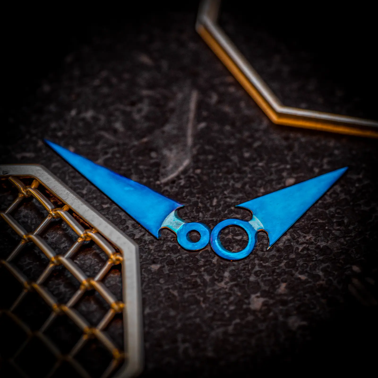 Heat-blued steel hands of The Octagon against the silver mesh dial